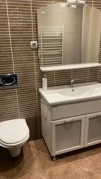 Bathroom equipped with a vanity, cabinet, mirror, and toilet. - image 22