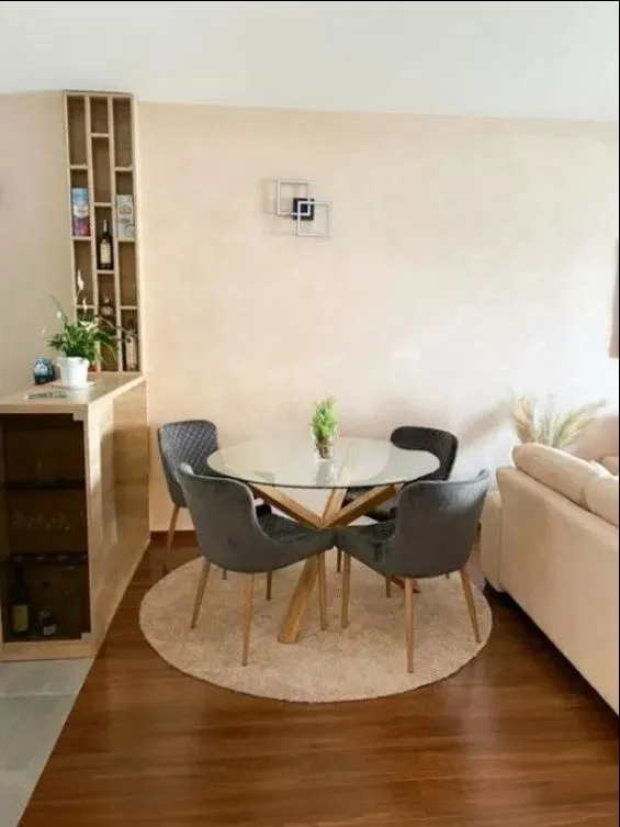 Living room with a dining table, four chairs, and a built-in shelving unit.