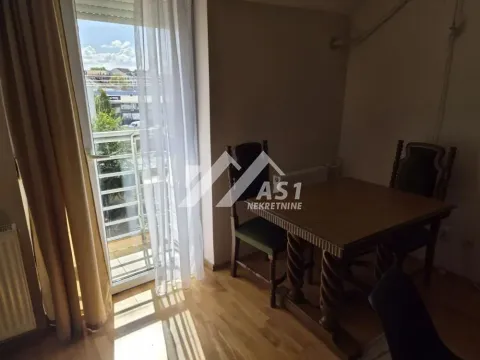 Trpezarija sa drvenim stolom i stolicama i izlazom na terasu. - image 7