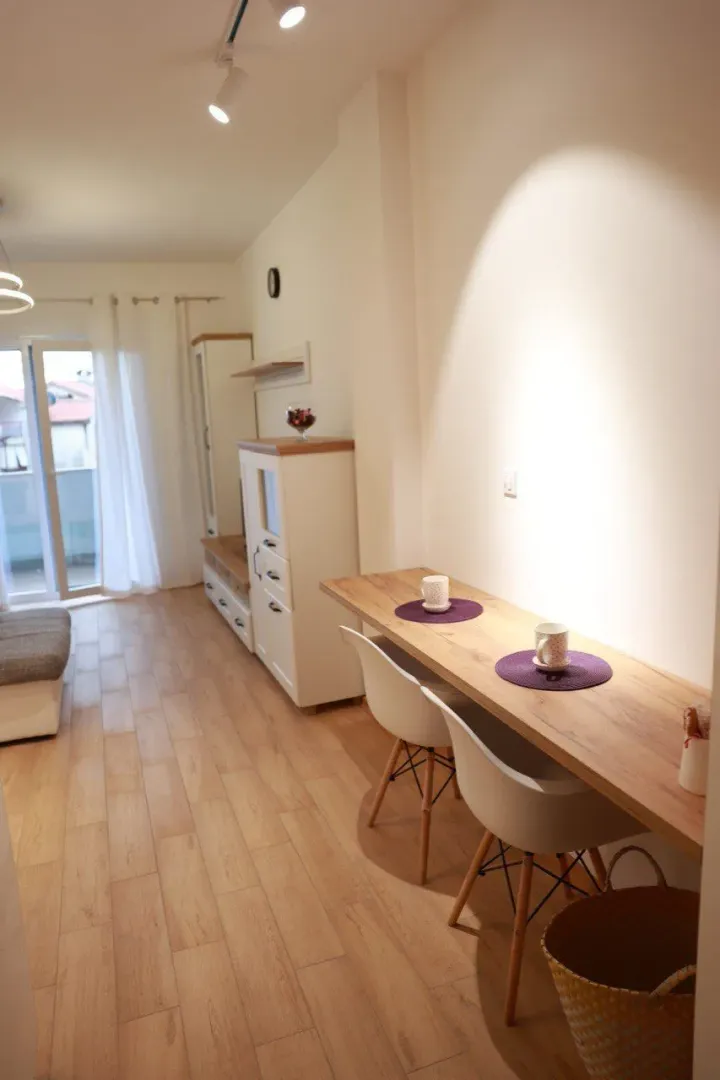Living room with a wall-mounted dining table and access to the terrace.