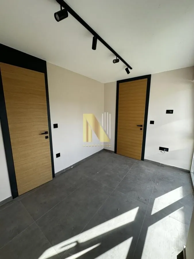 Empty room with two doors and ceramic tile flooring.