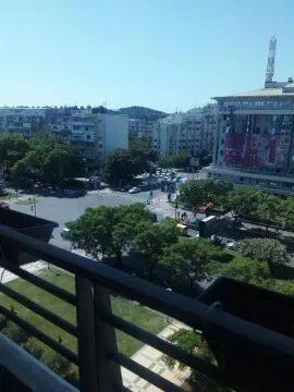 View from the balcony overlooking a city square and surrounding buildings. - image 8
