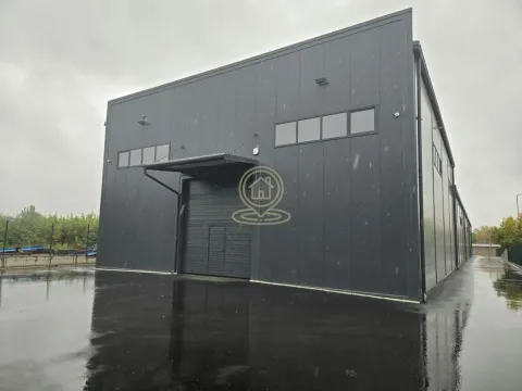 Exterior view of a modern industrial hall with a large door and paved courtyard. - image 5