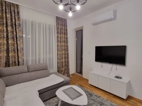 Living room with a sectional sofa, television, and air conditioning unit. - image 8