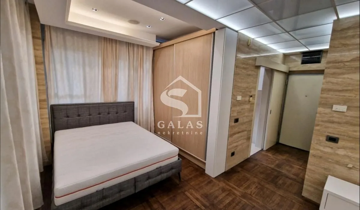 Furnished bedroom with a double bed and a built-in wardrobe.