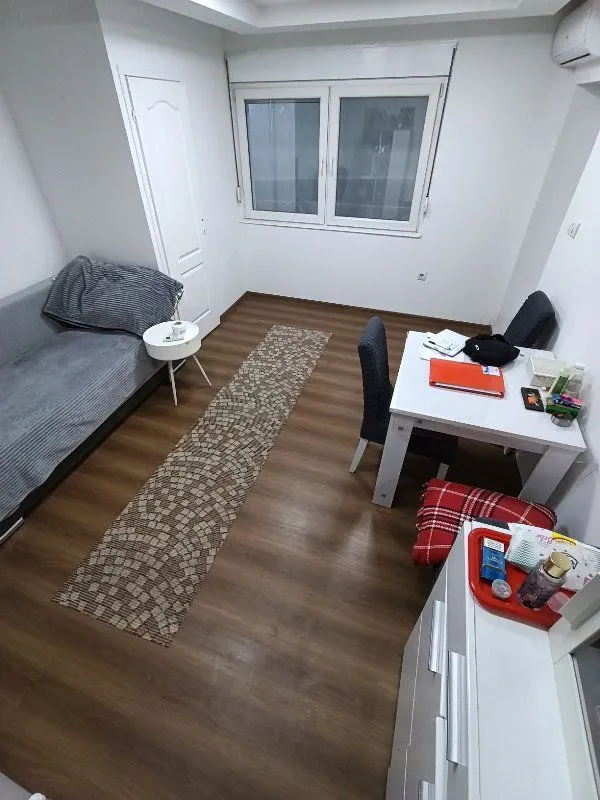 Dnevna soba sa kaučem, trpezarijskim stolom i prozorom.