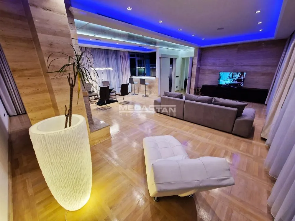 Spacious living room with a sofa set, dining area, and parquet flooring.