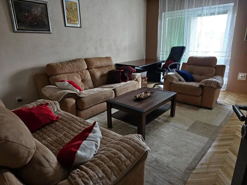 Dnevna soba sa garniturom za sjedenje i stočićem.