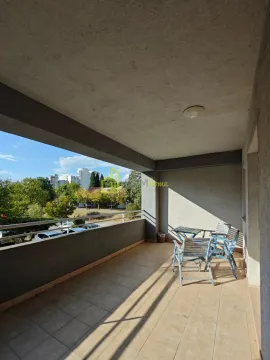 Spacious covered balcony with outdoor furniture and a view of the surroundings. - image 5