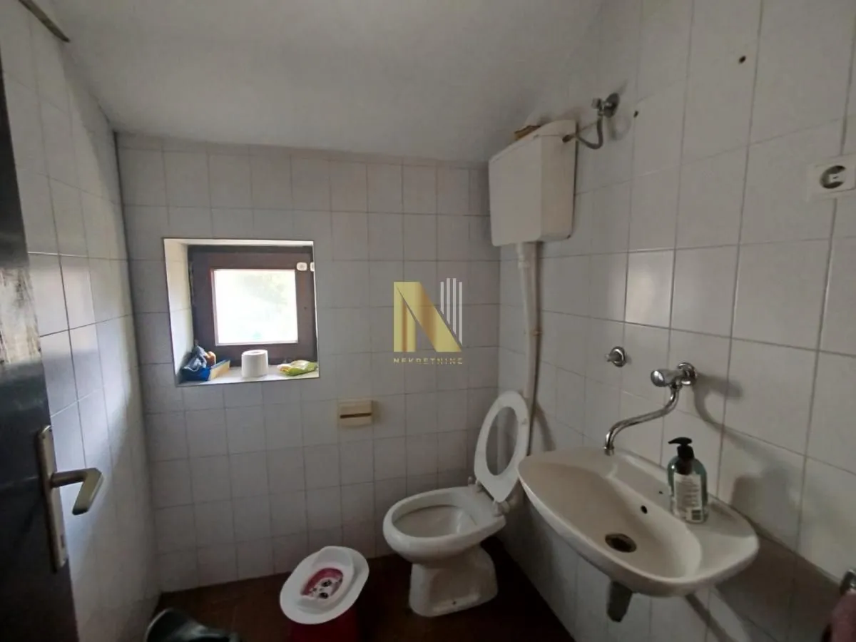 Smaller bathroom with a sink, toilet, and a small window.