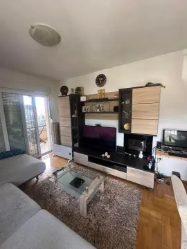 Dnevna soba sa garniturom, televizorom i izlazom na terasu. - image 3