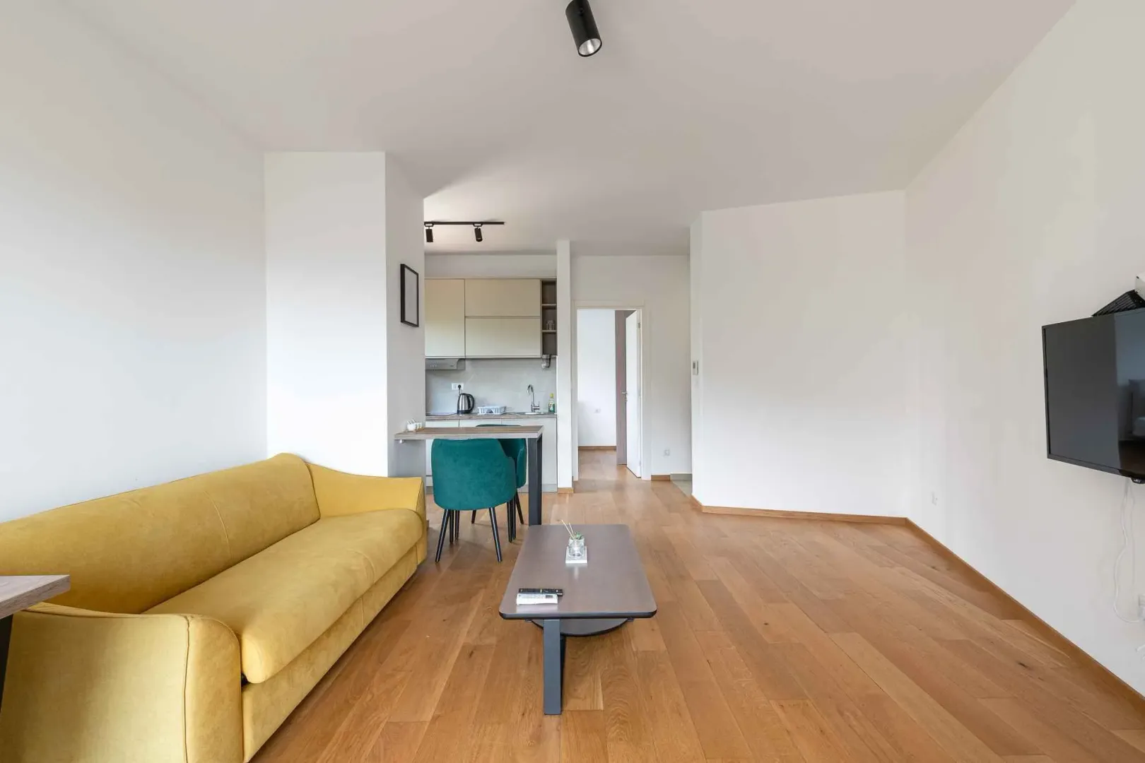 Spacious living room with a sofa and dining area in the background.