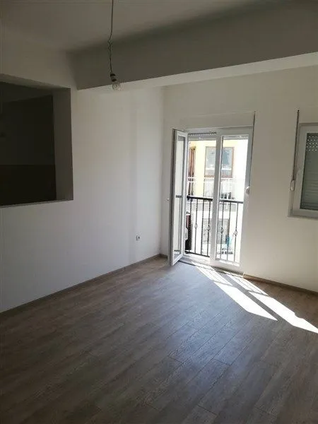 Prazna soba sa izlazom na balkon i svijetlim zidovima.