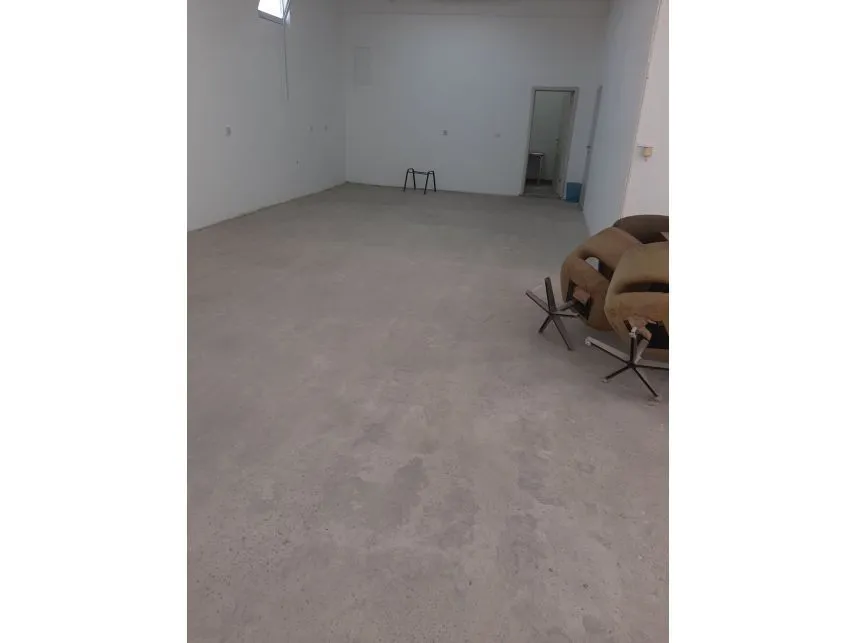 Spacious empty room with a concrete floor.