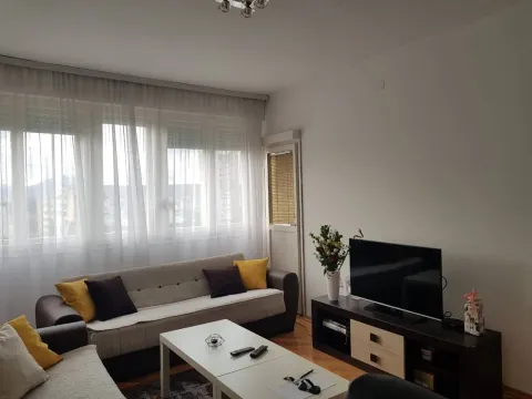 Bright living room with a sofa, coffee table, and TV. - image 7