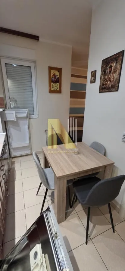 Manja kuhinja sa trpezarijskim stolom i stolicama.