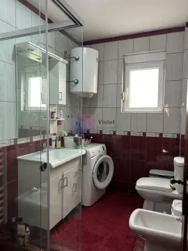Bathroom equipped with a shower cabin, washbasin, washing machine, and sanitary ware. - image 5