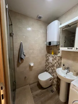 Manje kupatilo sa tuš kabinom, umivaonikom i wc šoljom obloženo keramičkim pločicama. - image 10
