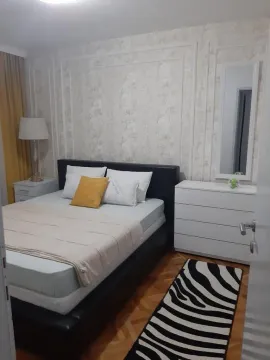 Furnished bedroom with a double bed, chest of drawers, and a mirror. - image 5