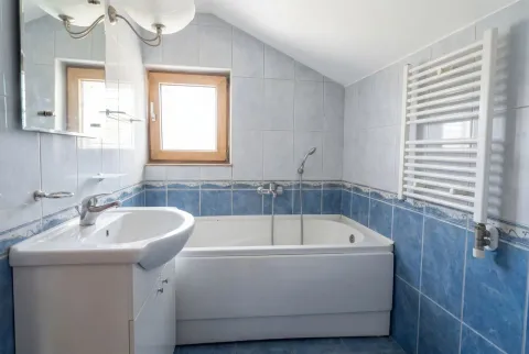 Svijetlo kupatilo sa plavim zidnim pločicama, kadom i lavaboom. - image 10