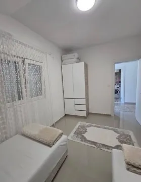 Manja spavaća soba sa krevetom, ormarom i prozorom. - image 11