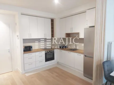 Modern kitchen with white cabinetry and built-in appliances. - image 2