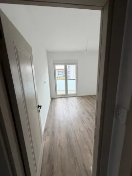 Empty room with hardwood floors and terrace access, viewed through a doorway. - image 4