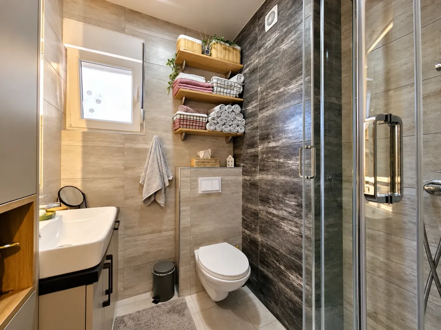 Modernly equipped bathroom with a shower cabin, washbasin, and wall-hung toilet.