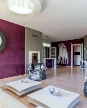 Dnevna soba sa modernim nameštajem, ljubičastim zidovima i kaminom. - image 2