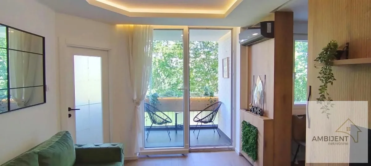 Living room with access to the terrace and green furniture.