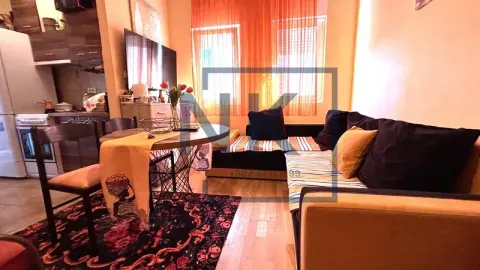 Living room with a sofa set, dining table, and a part of the kitchen in the background. - image 2