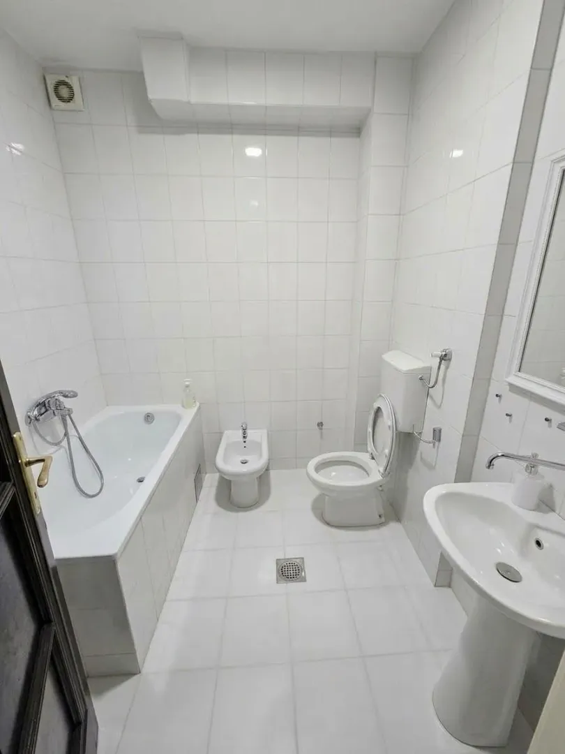 Bright equipped bathroom with a bathtub, washbasin, and sanitary fixtures.