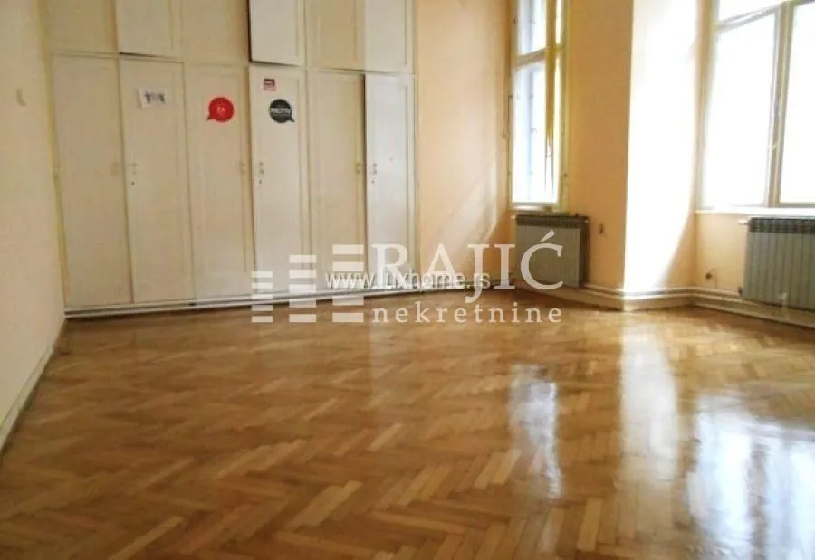 Empty room with parquet flooring and built-in wardrobes.