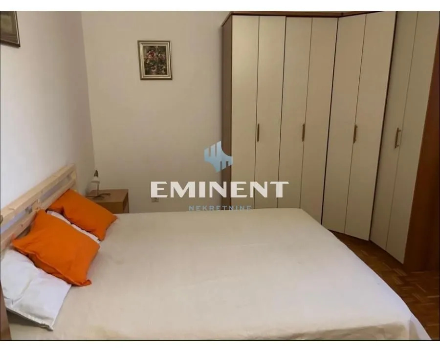 Furnished bedroom with a double bed and a large wardrobe.