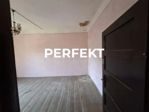 Prazna prostorija sa drvenim podom i ružičastim zidovima kojima je potrebno renoviranje. - image 2