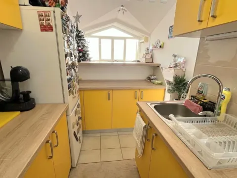 Manja kuhinja sa žutim elementima i sudoperom u prvom planu. - image 4