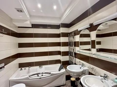 Modern bathroom with striped tiles, a jacuzzi tub, and two sinks. - image 7