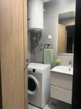A bathroom with a washing machine, sink, and water heater. - image 15