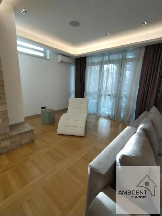 Living room with sofa and parquet flooring.