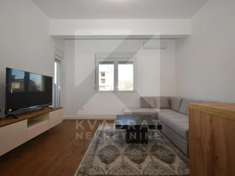 Living room with a sectional sofa, TV, and coffee table. - image 2
