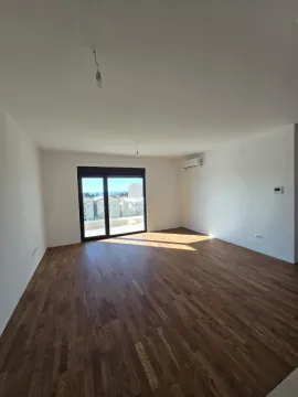 Prazna soba sa drvenim podom i izlazom na balkon. - image 9