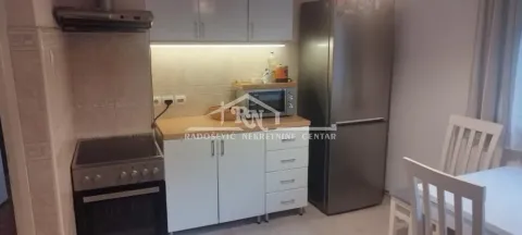 Kitchen equipped with kitchen units, stove, and refrigerator, featuring a dining table in the corner. - image 4