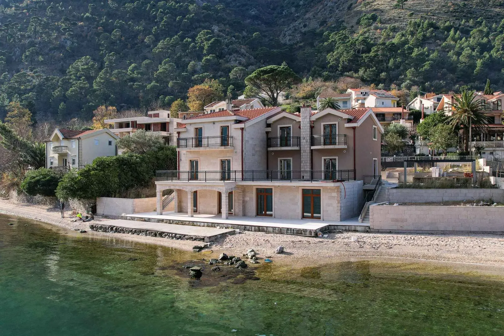 Eksterijer višespratne kuće sa pogledom na more i plažu.