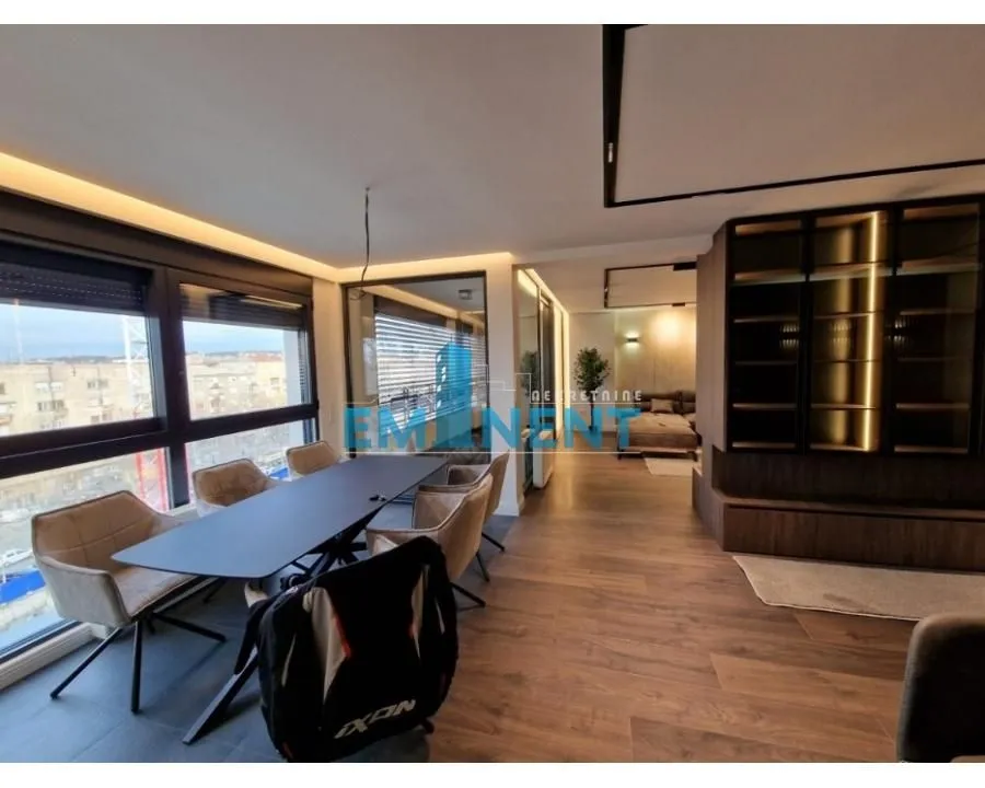 Living room with a dining area and large windows overlooking the surroundings.