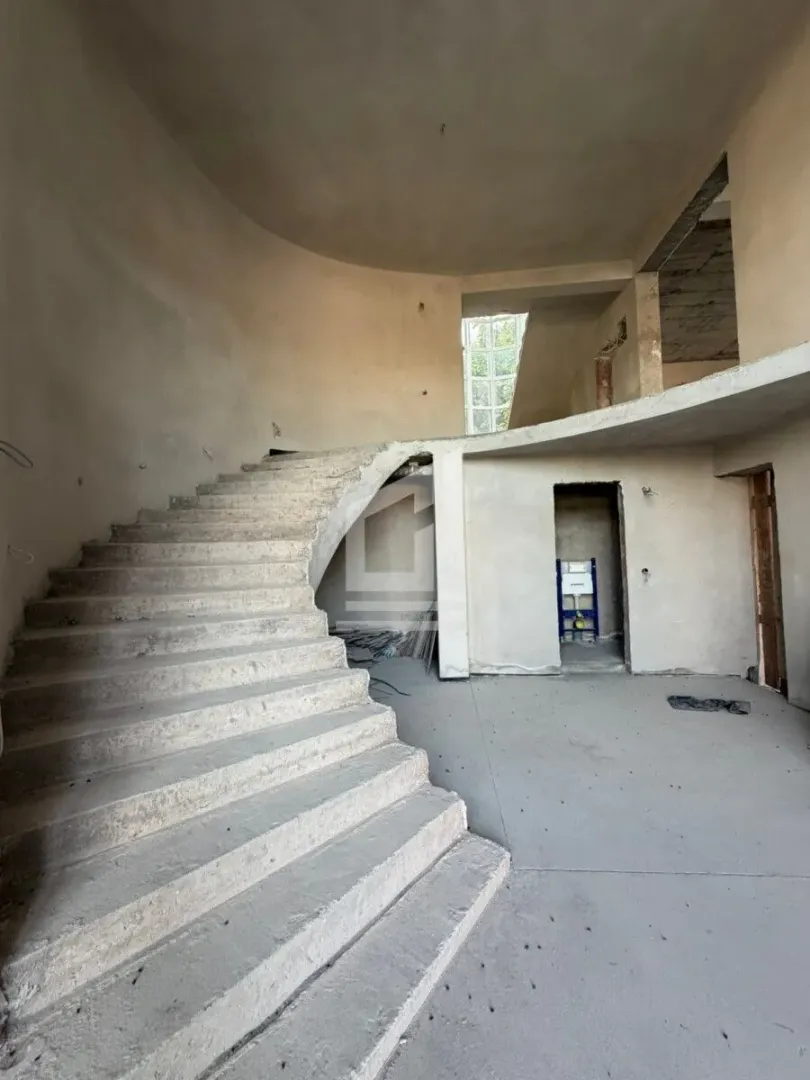 Unutrašnjություն objekta u izgradnji sa betonskim stepeništem.