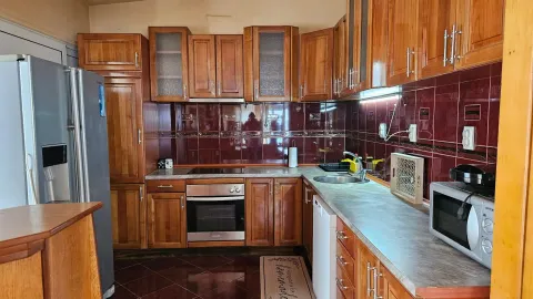 Kitchen with wooden cabinetry, countertops, and built-in appliances. - image 4