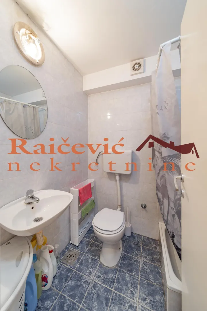 Small bathroom with sanitary facilities, a washbasin, and a bathtub with a curtain.