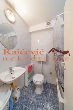Small bathroom with sanitary facilities, a washbasin, and a bathtub with a curtain. - image 12