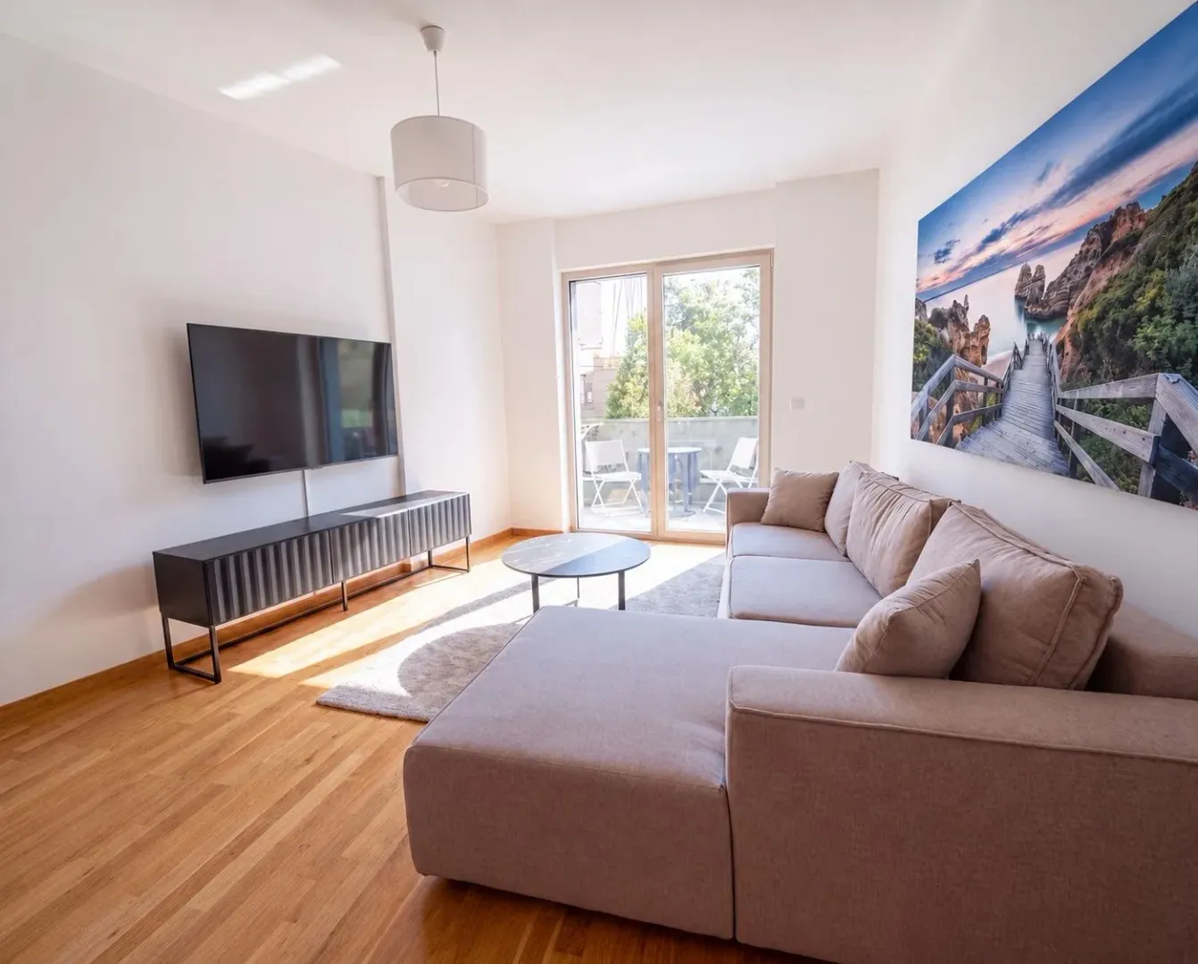 Living room with a sectional sofa, TV, and access to the terrace.
