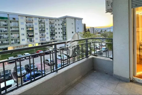 Balcony with metal railing and a view of the parking lot and surrounding buildings. - image 5